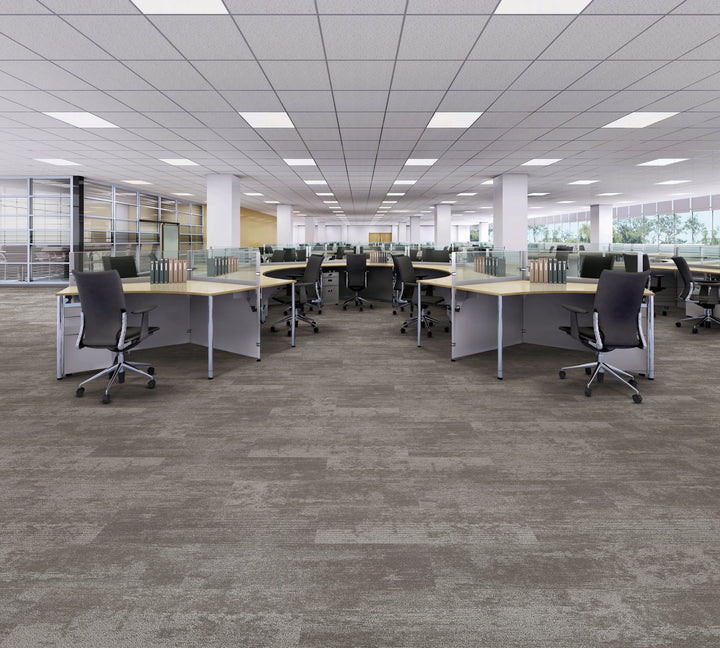 Modern office space with desks, chairs, and large windows.