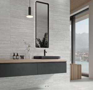 Interior setting showcasing a wall tiled with beige porcelain tiles, featuring a large mirror and a black sink on a wooden countertop.