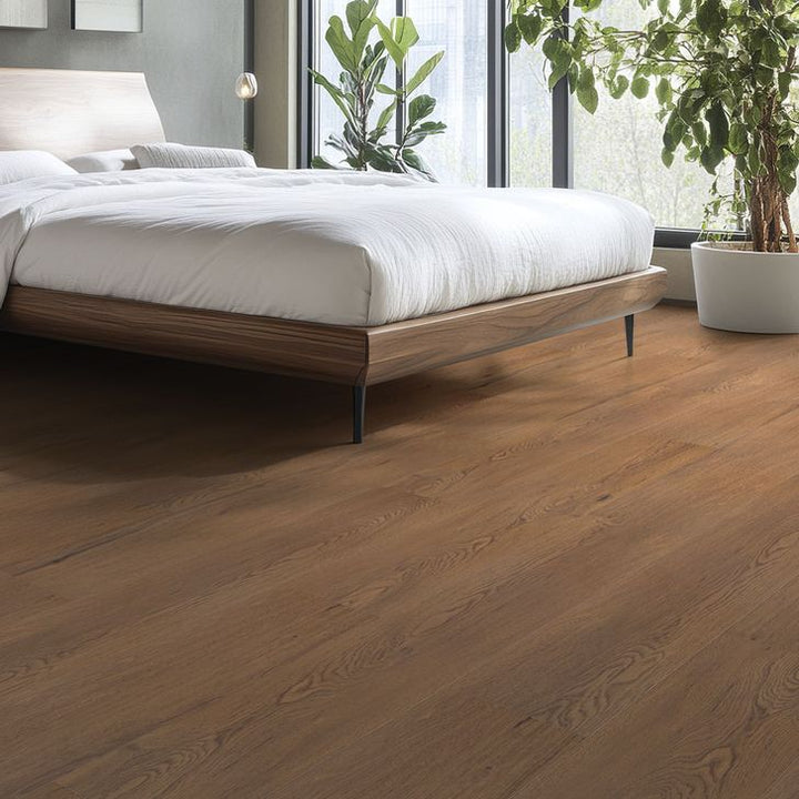Bedroom with wooden flooring, bed, and plants