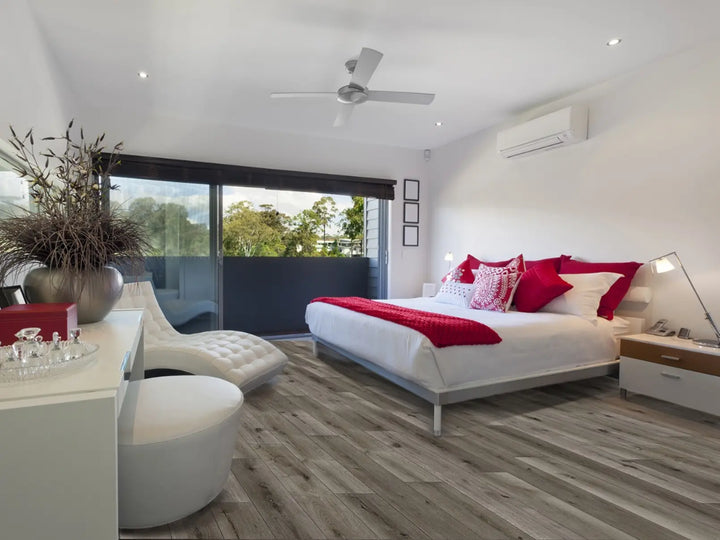 Modern bedroom with a bed, red blanket, and white furniture.