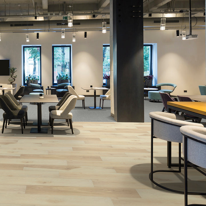 Modern office space with tables, chairs, and large windows.