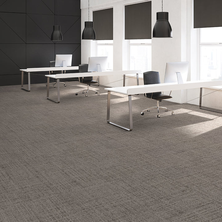 Modern office with white desks, chairs, and black pendant lights.