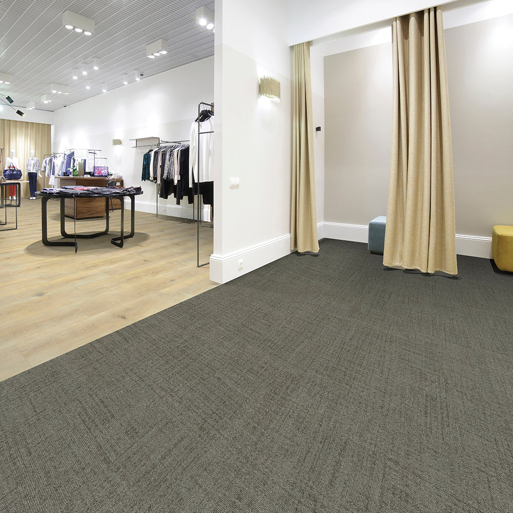 Modern office interior with gray carpet, beige curtains, and wooden flooring.