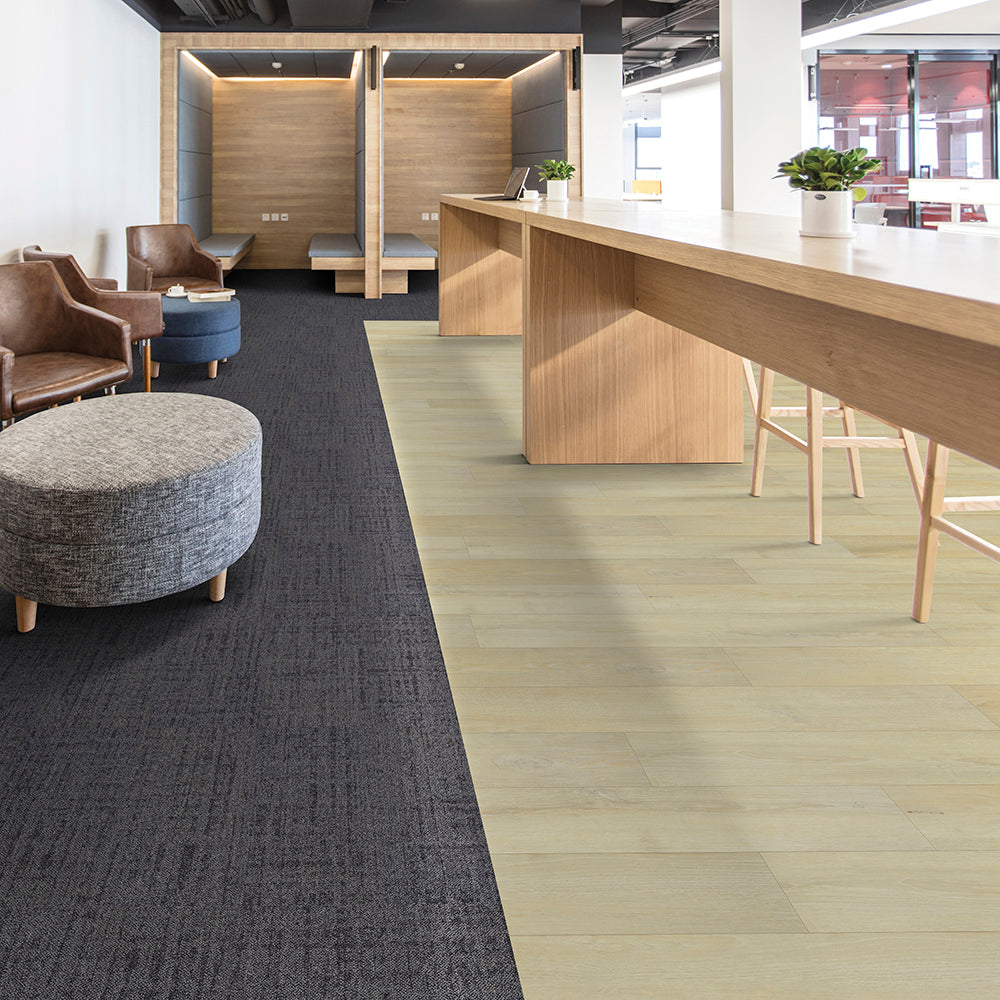 Modern office interior with a reception desk, chairs, and a gray rug.