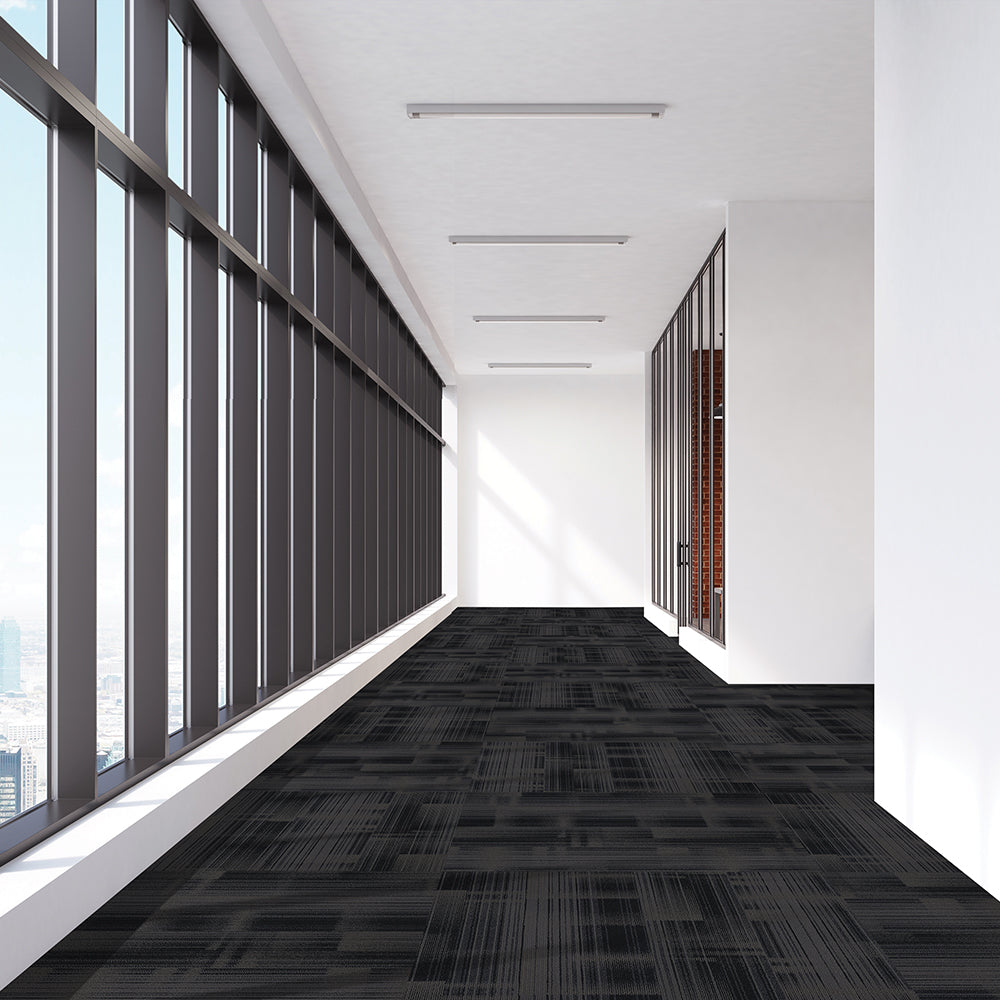 Modern office hallway with large windows and a black patterned carpet.