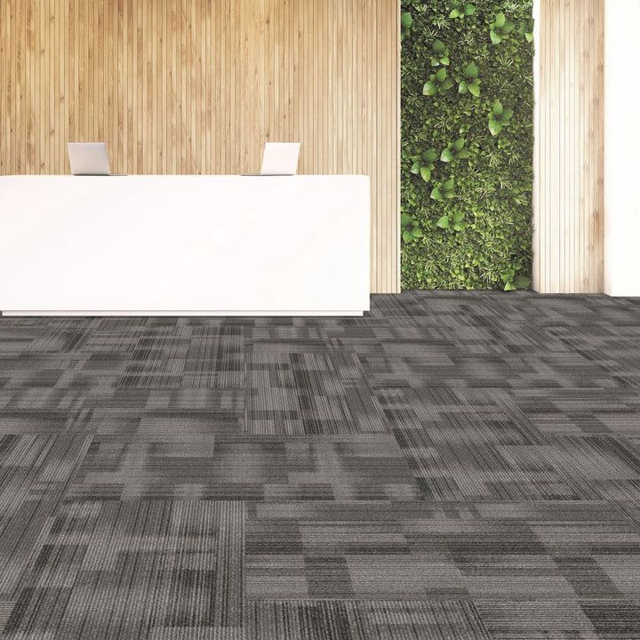 Gray patterned carpet in a room with wooden walls and a green plant wall.