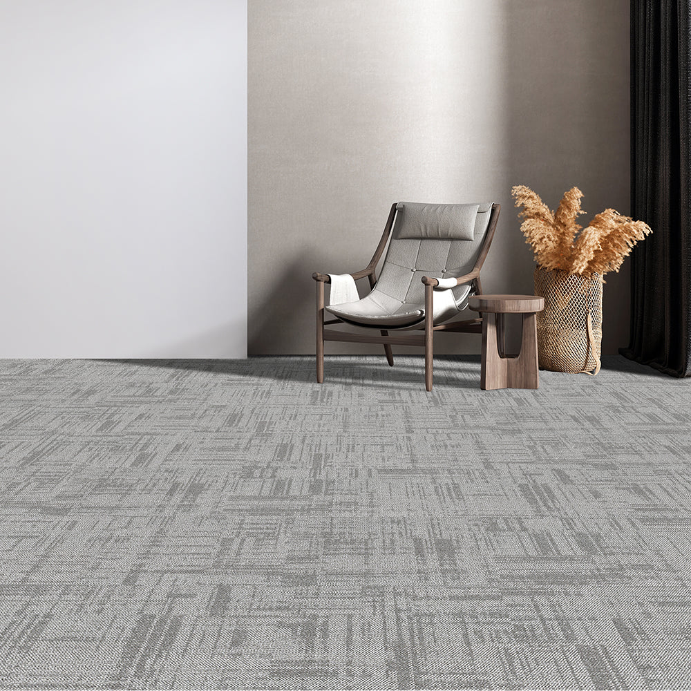 Gray patterned carpet in a room with a chair and decorative elements.