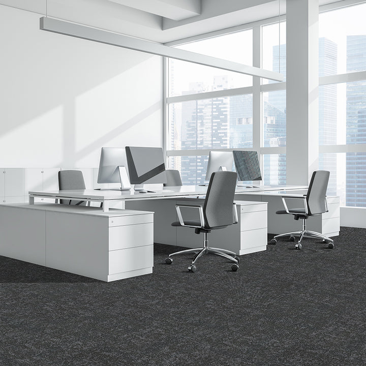 Modern office setup with white desks, chairs, and computer monitors in a bright room.