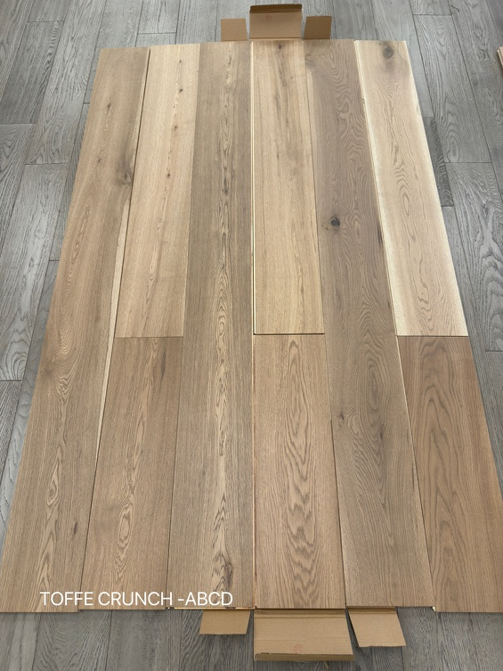 Planks of Toffee Crunch ABCD Grade VIDAR premium European Oak engineered hardwood flooring.