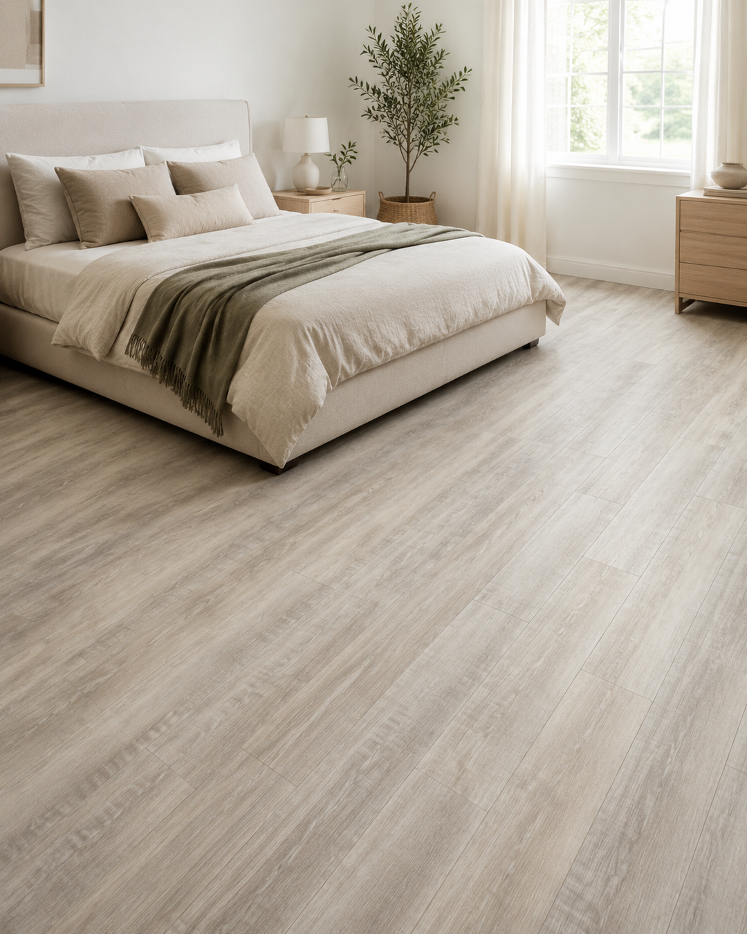 Light gray wood-look laminate or vinyl flooring shown in a bright, modern bedroom setting with a bed, nightstands, and window.