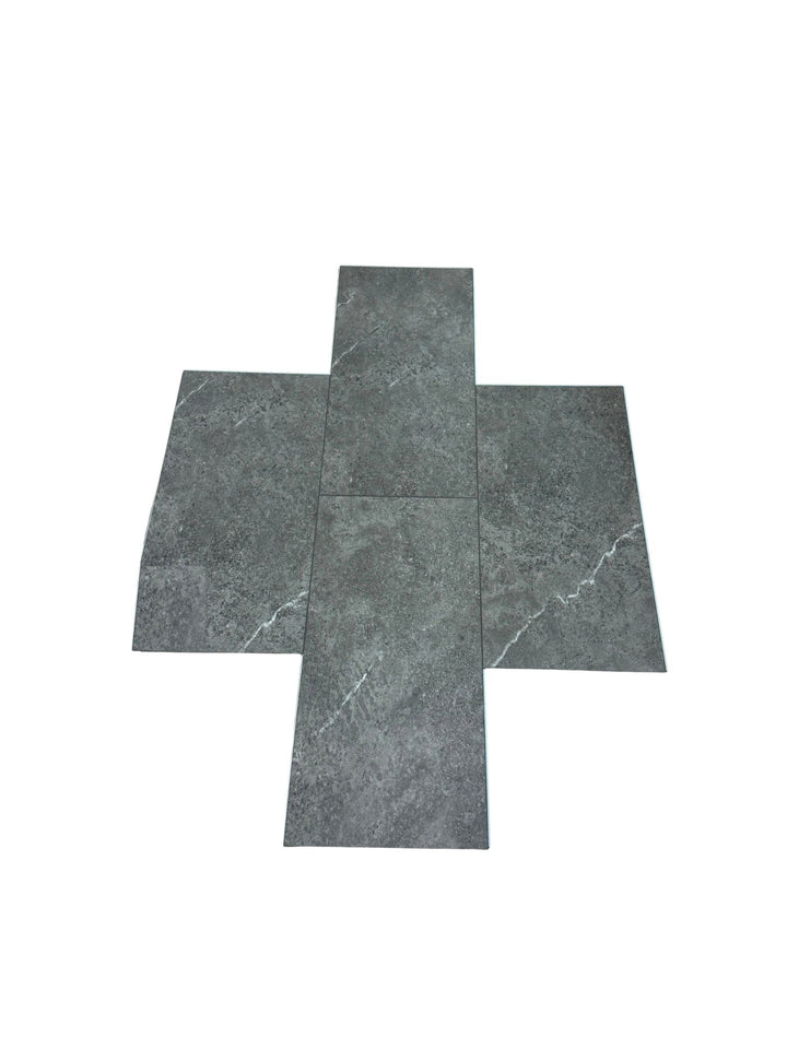 Four dark gray stone-look vinyl tiles arranged in a cross-like flat layout on a plain white background. Available at Advanced Flooring. 