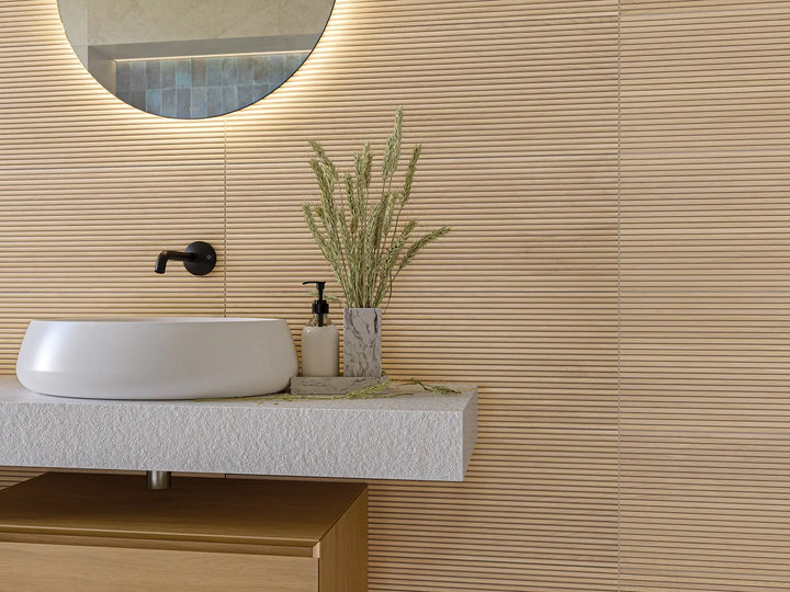 Bathroom vanity with a sink, mirror, and decorative plant against a wooden wall.