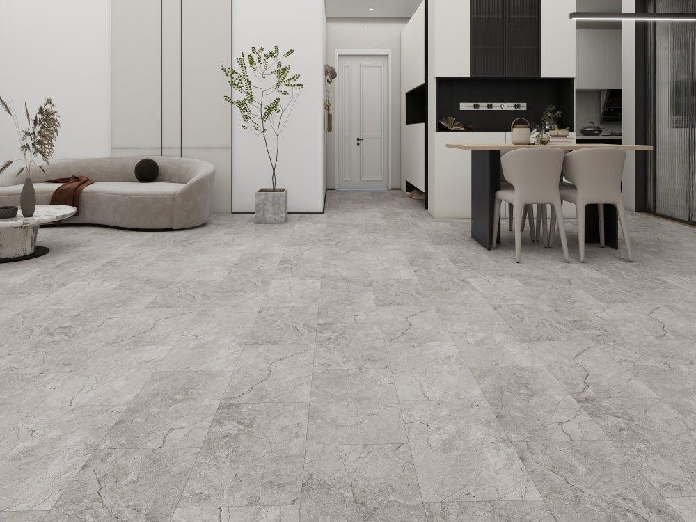 Modern living room with gray tiled floor, sofa, and kitchen area.