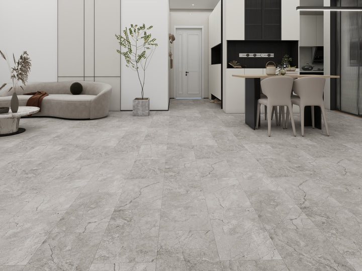 Modern living room with gray tiled floor, sofa, and kitchen area.