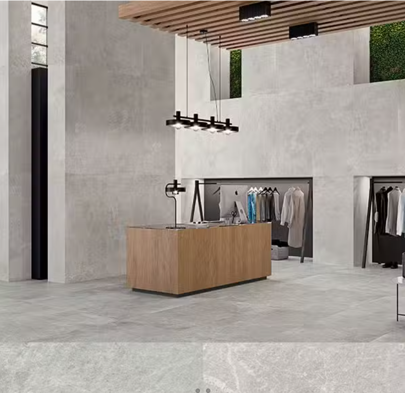 A retail space with light grey porcelain tiles on the floor. The tiles have a matte finish and are installed in a large area, complementing the modern interior of the store.