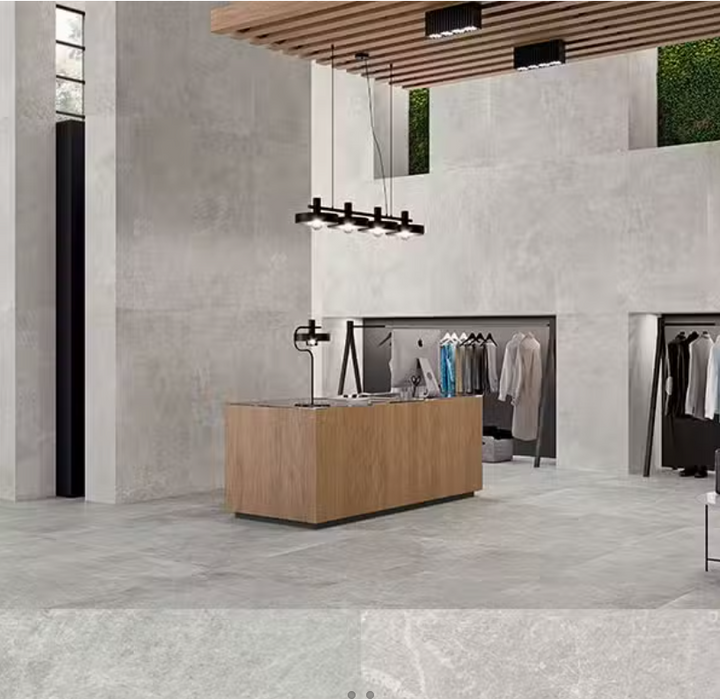 A retail space with light grey porcelain tiles on the floor. The tiles have a matte finish and are installed in a large area, complementing the modern interior of the store.