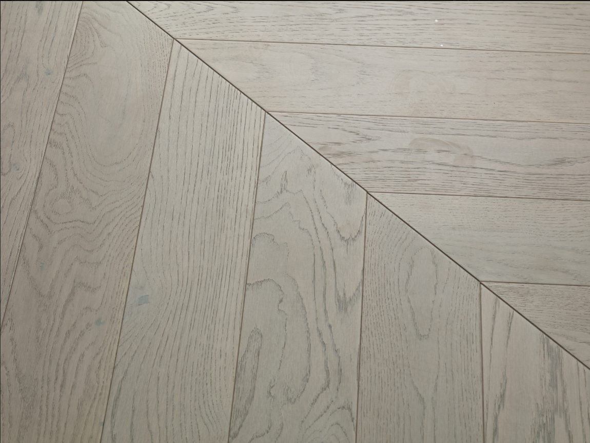 A close up of Snow Flake VIDAR premium American oak engineered hardwood flooring in chevron.