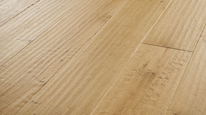 Close-up of Terracotta engineered hardwood flooring from the Atelier Collection featuring hand-scraped white oak with natural brown tones and 3 mm veneer.