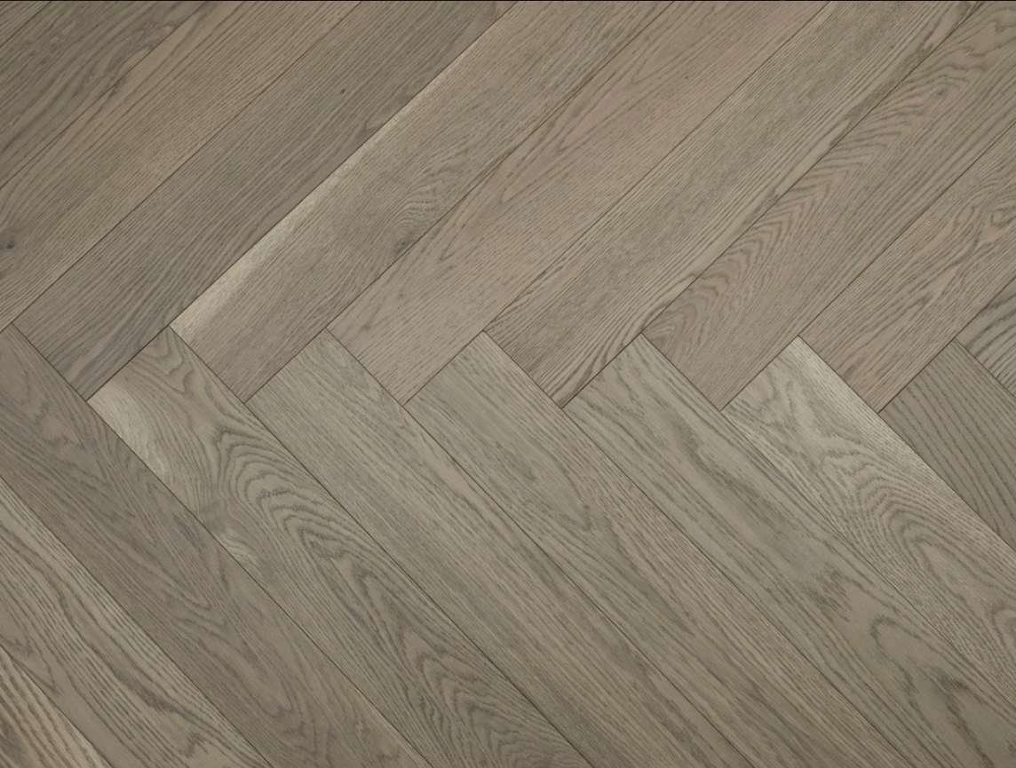 A close up of Toffee Crunch VIDAR premium 5” American oak engineered hardwood flooring in herringbone.