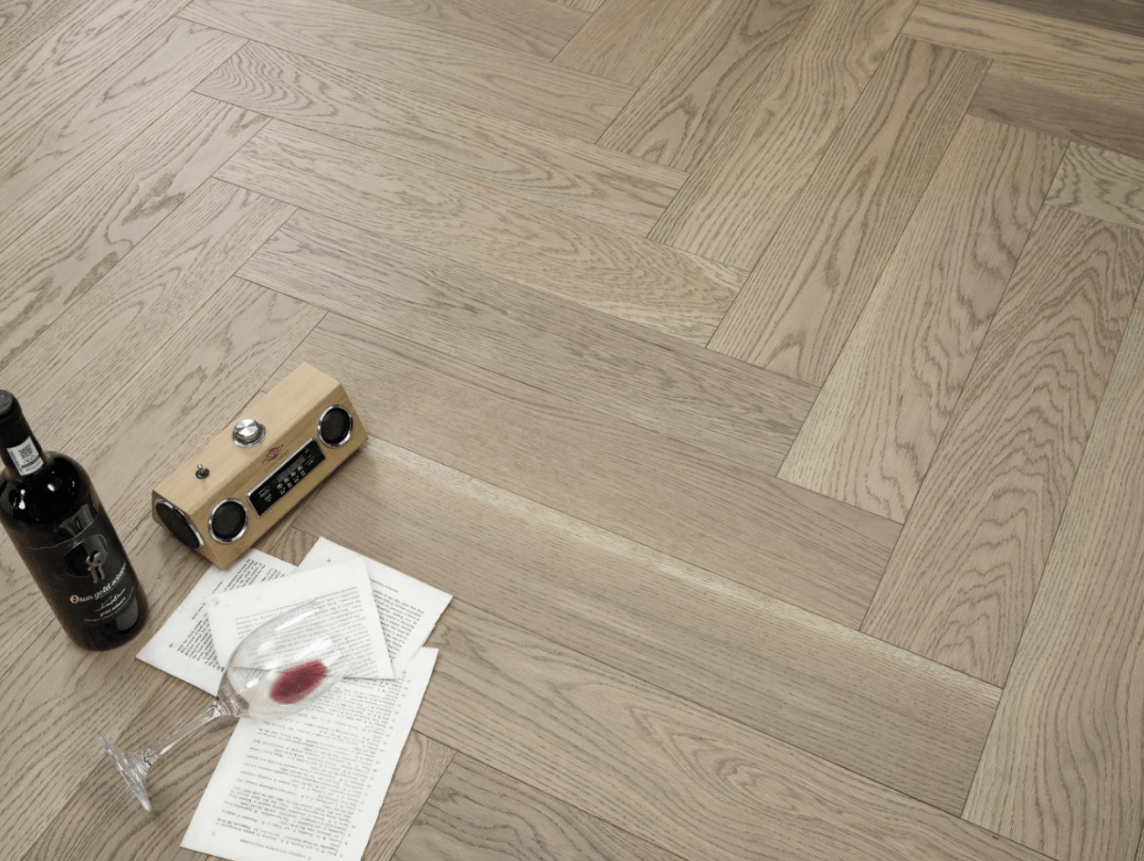 A modern room which displays the beautiful look of Toffee Crunch premium herringbone engineered hardwood flooring from Vidar.