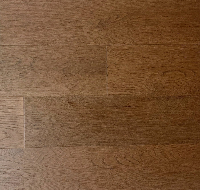 Close-up of a wooden floor with a warm brown color and visible grain pattern.
