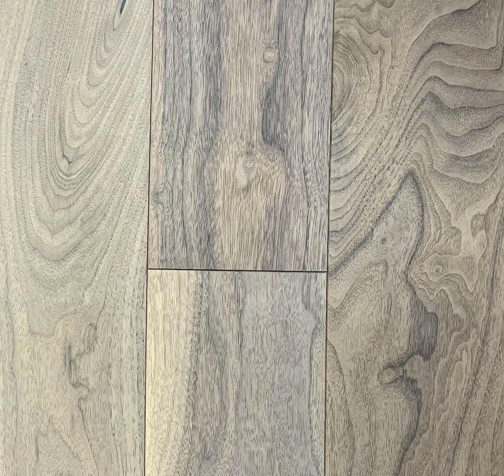 A close up of Provence 8 1/4" x 3/4" Wire Brushed VIDAR premium American Black Walnut engineered hardwood flooring.
